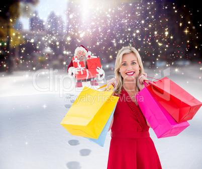 Composite image of stylish blonde in red dress holding shopping