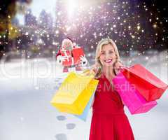 Composite image of stylish blonde in red dress holding shopping