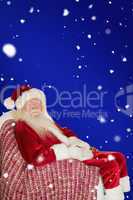 Composite image of smiling santa relaxing on the armchair