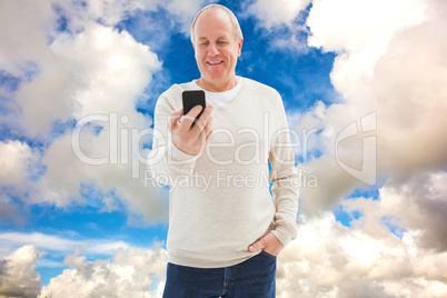Composite image of happy mature man sending a text