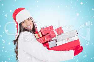 Composite image of festive brunette in winter clothes holding ma