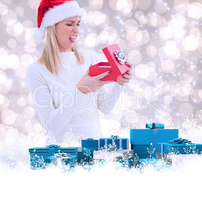 Composite image of disappointed blonde opening christmas gift