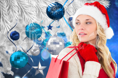 Composite image of happy festive blonde with shopping bag