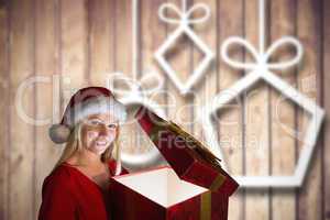 Composite image of festive blonde holding a gift