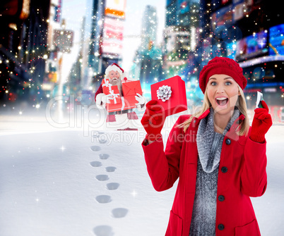 Composite image of festive blonde holding gift and credit card