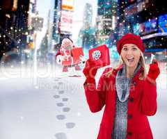 Composite image of festive blonde holding gift and credit card