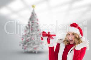 Composite image of excited blonde in santa hat holding gift