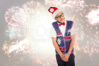 Composite image of geeky hipster in santa hat