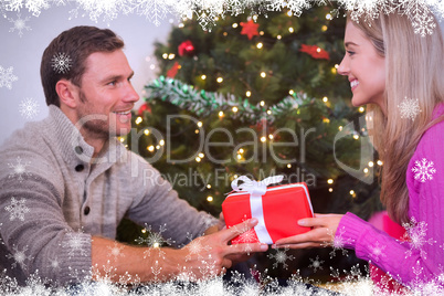 Composite image of sitting couple giving each other presents