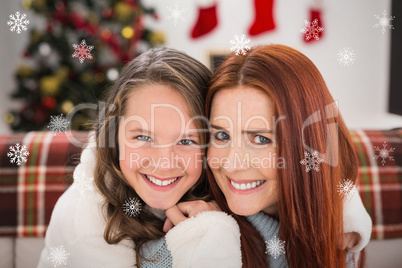 Composite image of festive mother and daughter on the couch