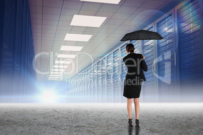 Composite image of young businesswoman holding umbrella