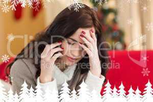 Composite image of concentrated brunette on the phone on christm
