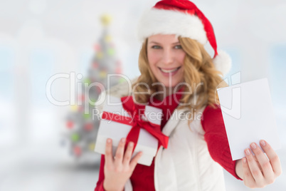 Composite image of festive blonde holding christmas gift and sho