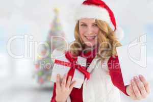 Composite image of festive blonde holding christmas gift and sho