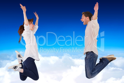 Composite image of couple jumping in the air