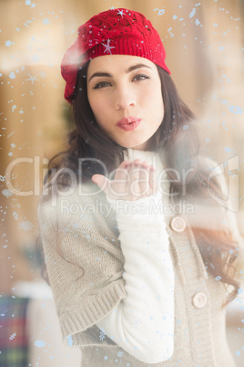 Composite image of pretty brunette blowing a kiss