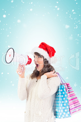 Composite image of festive brunette holding megaphone and bags