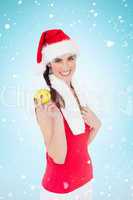 Composite image of festive fit brunette holding apple