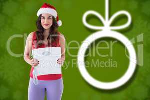 Composite image of festive fit brunette holding page and measuri