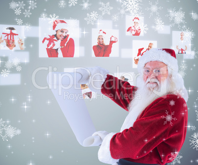 Composite image of father christmas holds a list