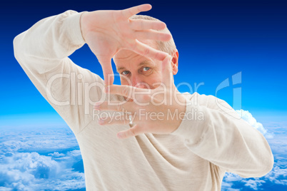 Composite image of happy mature man framing with hands