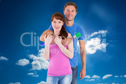 Composite image of couple hugging and holding brush