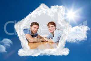 Composite image of couple lying on the floor