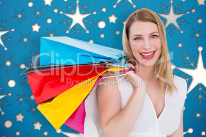 Composite image of pretty woman carrying shopping bags over her