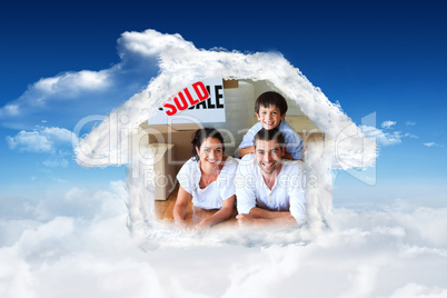 Composite image of family in their new house lying on floor with