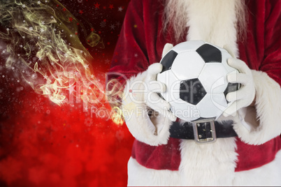 Composite image of santa holds a classic football