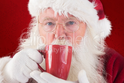 Composite image of santa drinks from a red cup