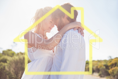 Composite image of attractive couple embracing by the road