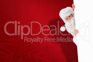 Composite image of smiling santa claus presenting sign