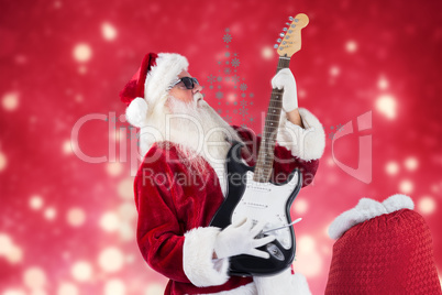 Composite image of santa playing electric guitar