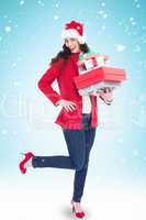 Composite image of excited brunette in red coat holding many gif