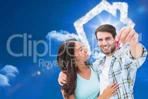 Composite image of happy young couple showing new house key