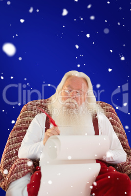 Composite image of father christmas writing list with a quill