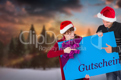 Composite image of couple holding a sign