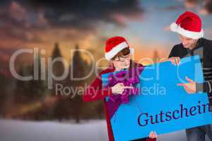 Composite image of couple holding a sign