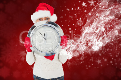 Composite image of festive woman holding clock