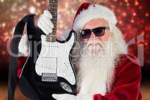 Composite image of father christmas shows a guitar