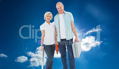 Composite image of happy older couple holding diy tools