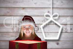 Composite image of festive blonde holding a gift