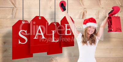 Composite image of festive blonde with boxing gloves and shoppin