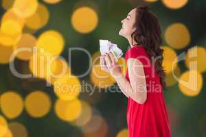 Composite image of stylish brunette in red dress holding cash