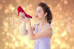 Composite image of elegant brunette kissing a shoe