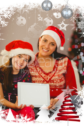 Composite image of festive mother and daughter showing tablet screen