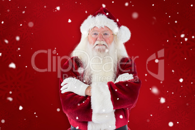 Composite image of santa smiles with folded arms