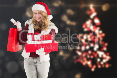 Composite image of festive blonde with shopping bag and gifts