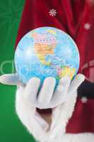 Composite image of santa has a globe in his hand